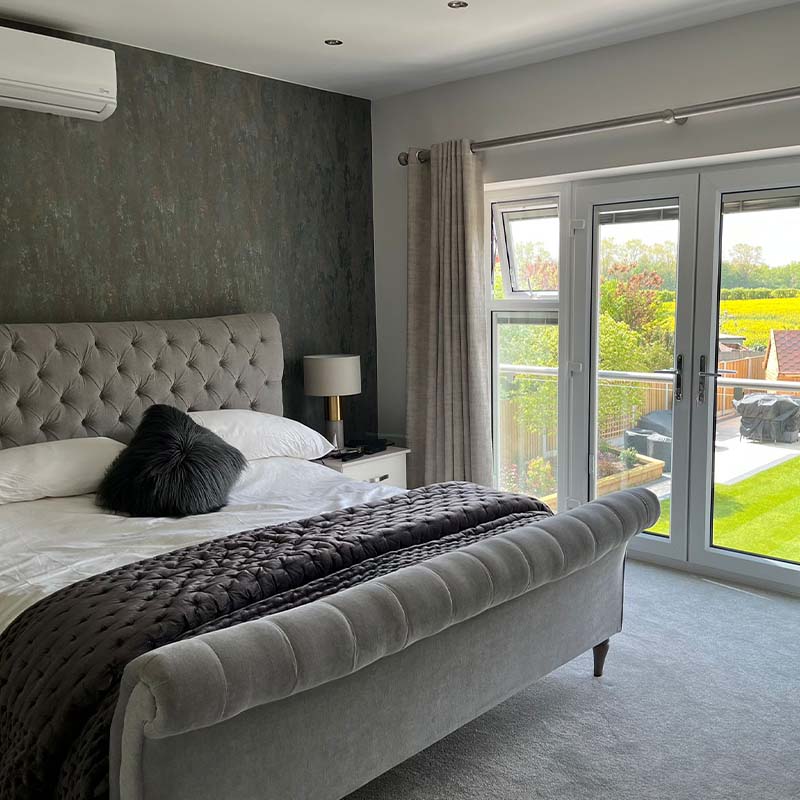 Photo shows remodelled & extended dormer bungalow into a two-story detached home in Culcheth, featuring a modern bedroom overlooking the beautiful garden